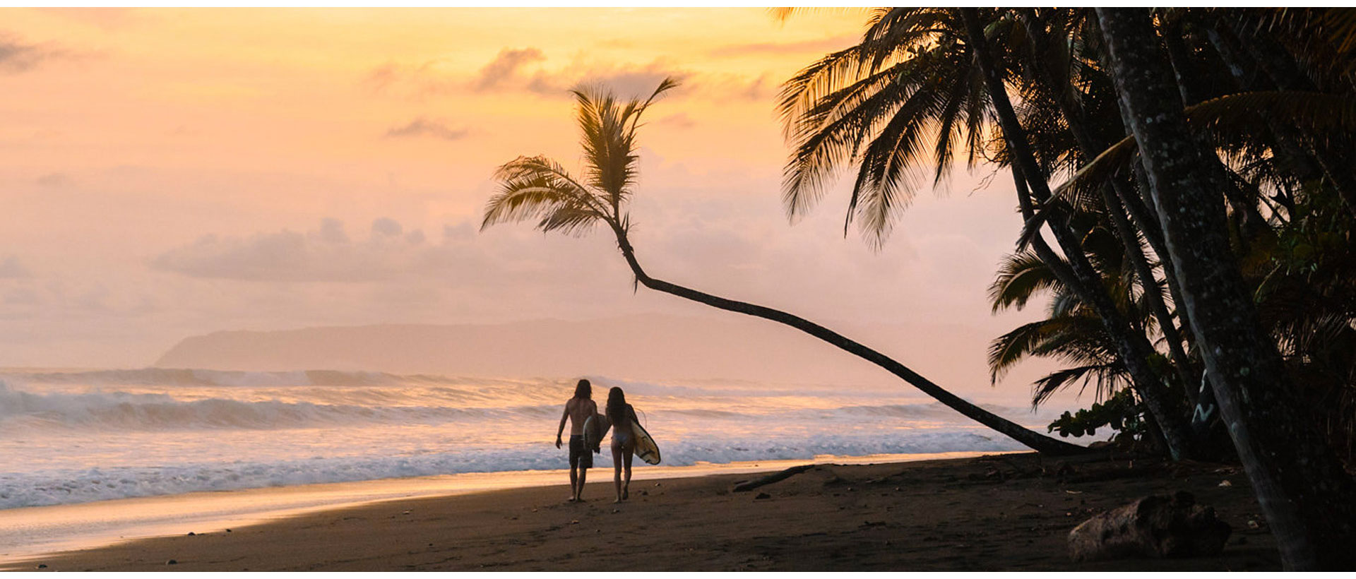 All inclusive surf vacation in Panama — couple on the beach with boards